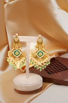 The original photo — the same earrings on a stand against a crumpled satin backdrop.